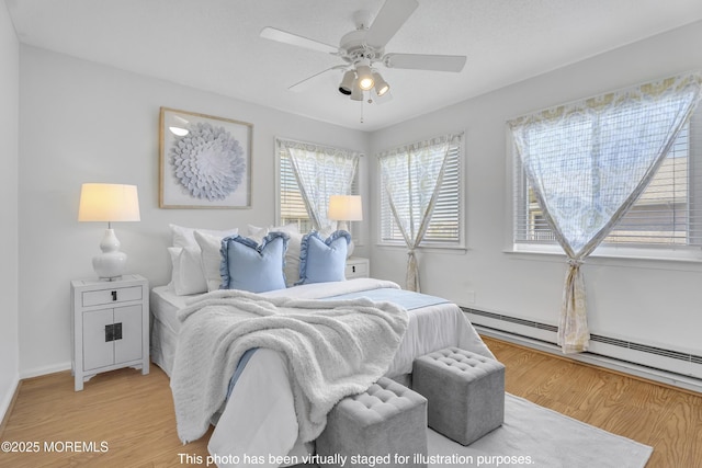 50 Valentine St Unit 14B, Monmouth Beach, NJ 07750 - bedroom with light wood-type flooring, baseboard heating, baseboards, and ceiling fan