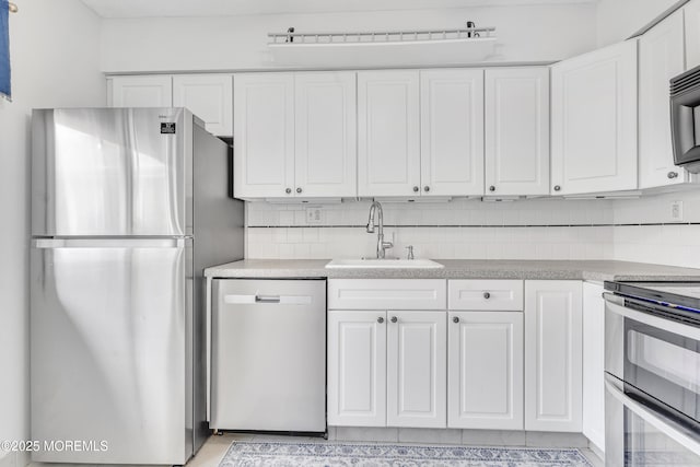 50 Valentine St Unit 14B, Monmouth Beach, NJ 07750 - kitchen featuring appliances with stainless steel finishes, a sink, white cabinets, and tasteful backsplash