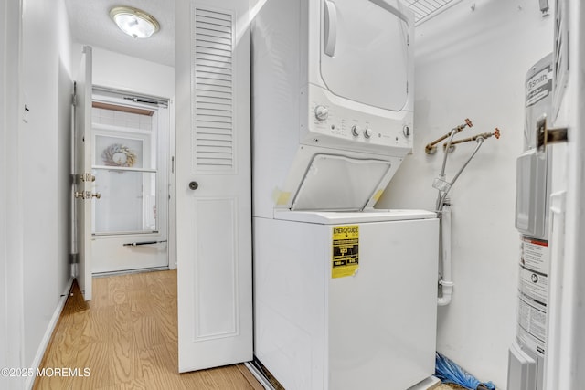 50 Valentine St Unit 14B, Monmouth Beach, NJ 07750 - clothes washing area featuring stacked washer / drying machine, light wood-style floors, and electric water heater