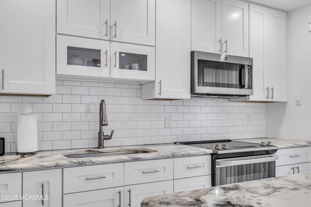 2 Oregon Dr Unit A, Whiting, NJ 08759 - kitchen with stainless steel appliances, a sink, white cabinetry, decorative backsplash, and light stone counters