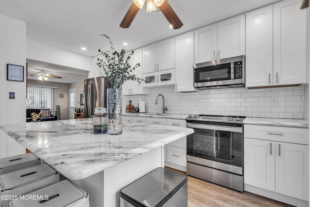 2 Oregon Dr Unit A, Whiting, NJ 08759 - kitchen with appliances with stainless steel finishes, a ceiling fan, a sink, a breakfast bar, and white cabinetry