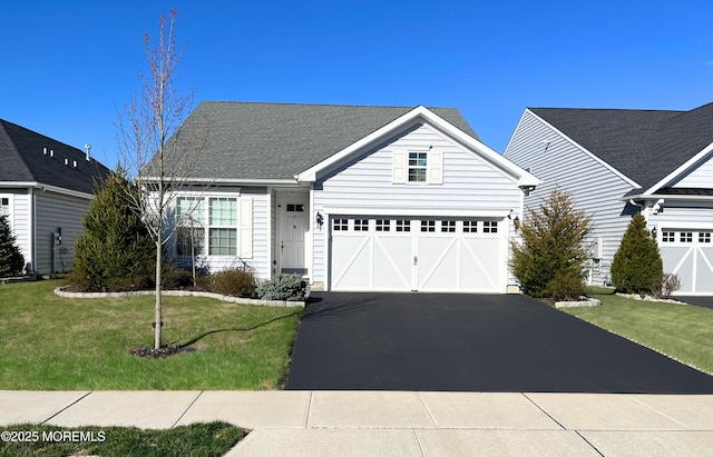 view of front of house featuring asphalt driveway and a front lawn