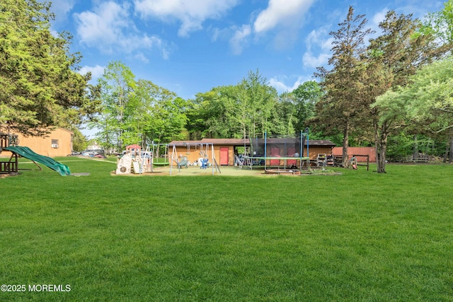 view of green lawn featuring a trampoline, a playground, a storage unit, and an outbuilding
