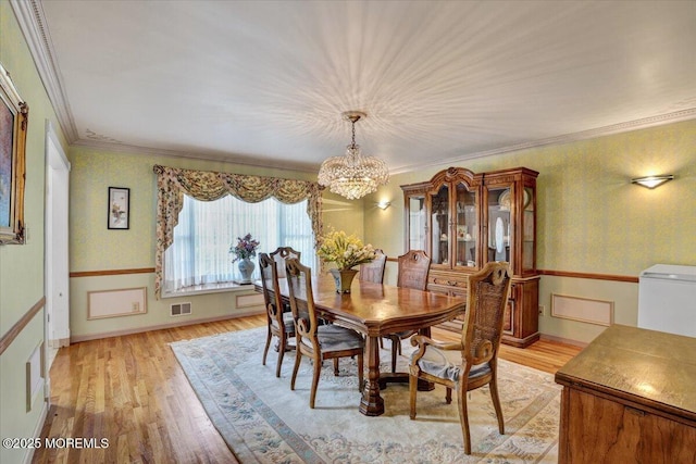 48 Joseph St, Manalapan, NJ 07726 - dining room featuring a chandelier, light wood-style flooring, wallpapered walls, crown molding, and baseboards