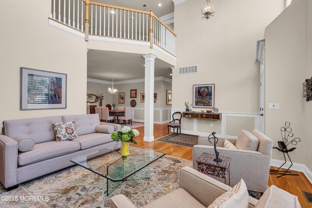 11 Aspen Ln, Tinton Falls, NJ 07724 - living room with decorative columns, crown molding, a high ceiling, baseboards, and a chandelier