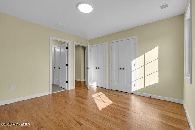 25 Blue River Way, Lakewood, NJ 08701 - unfurnished bedroom with multiple closets, baseboards, and wood finished floors
