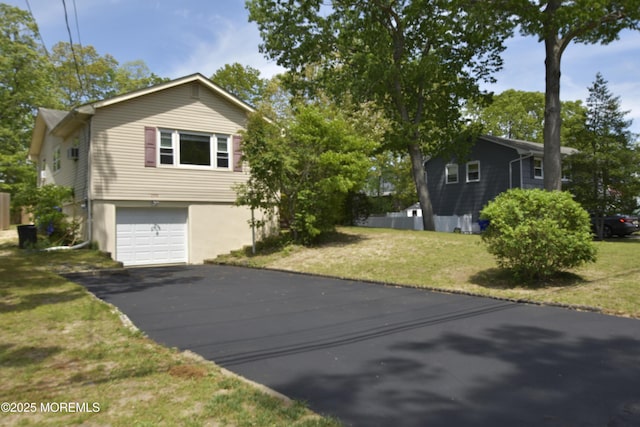 view of home's exterior with driveway, an attached garage, and a yard