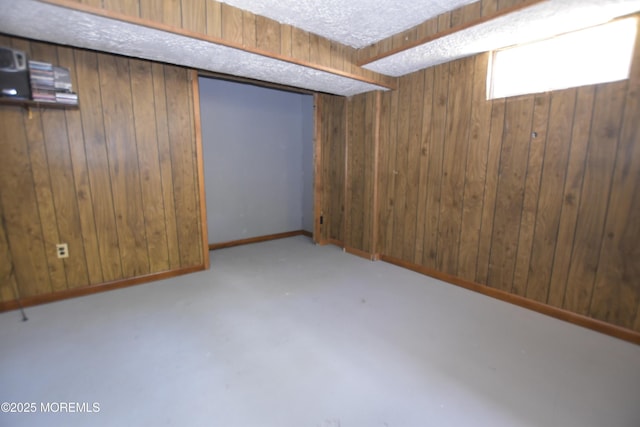 below grade area with wood walls and a textured ceiling
