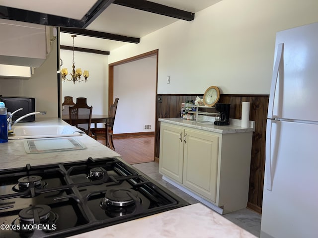 1595 Forge Pond Rd, Brick, NJ 08724 - kitchen with freestanding refrigerator, black gas stovetop, a wainscoted wall, beam ceiling, and a chandelier