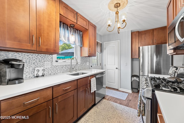 129 Foster Rd, Toms River, NJ 08753 - kitchen with stainless steel appliances, a sink, light wood-type flooring, tasteful backsplash, and brown cabinets