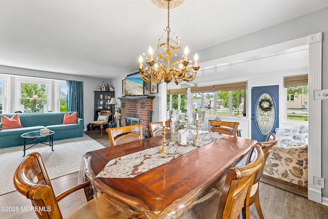 129 Foster Rd, Toms River, NJ 08753 - dining area with wood finished floors, healthy amount of natural light, a chandelier, and a brick fireplace