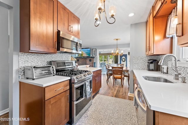 129 Foster Rd, Toms River, NJ 08753 - kitchen featuring a chandelier, appliances with stainless steel finishes, a sink, wood finished floors, and tasteful backsplash