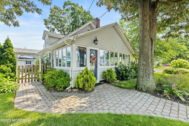129 Foster Rd, Toms River, NJ 08753 - view of front of house with a sunroom, a chimney, a patio area, and fence