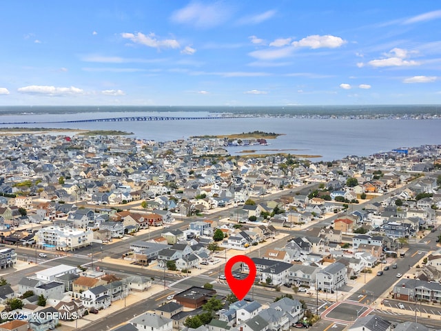 aerial view of property and surrounding area with a large body of water and nearby suburban area