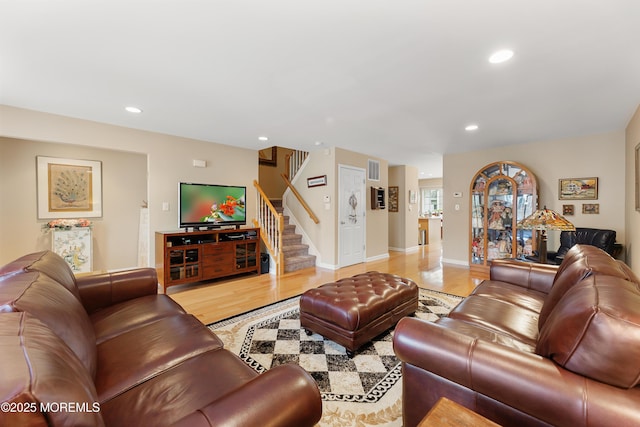 living area featuring stairs, light wood-style floors, recessed lighting, and baseboards