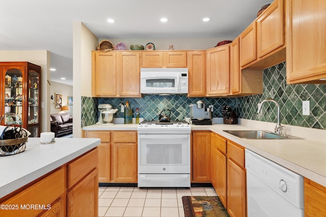kitchen featuring white appliances, a sink, light countertops, and recessed lighting