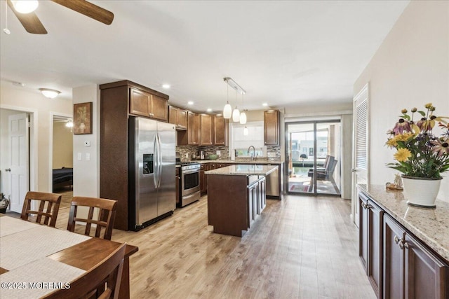 19 Acapulco Dr, Brick, NJ 08723 - kitchen featuring appliances with stainless steel finishes, tasteful backsplash, light wood finished floors, a sink, and a ceiling fan