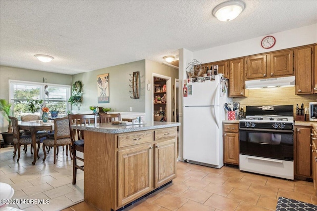 19 Acapulco Dr, Brick, NJ 08723 - kitchen featuring gas range oven, under cabinet range hood, freestanding refrigerator, a textured ceiling, and brown cabinets