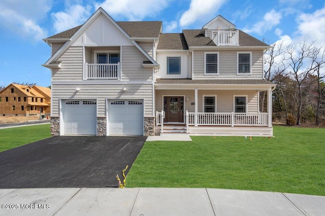 view of front of home with driveway, covered porch, an attached garage, a front lawn, and a shingled roof