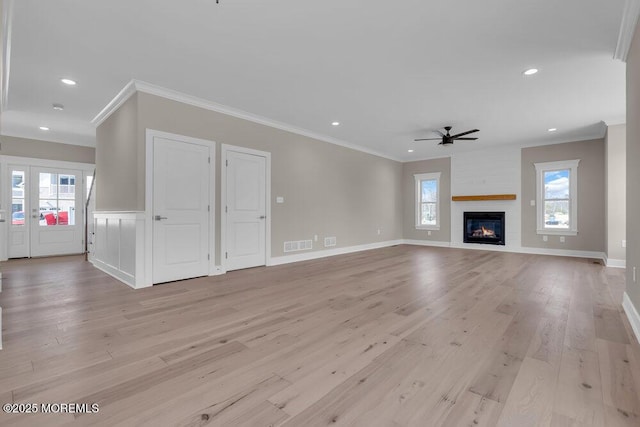 unfurnished living room with crown molding, a ceiling fan, light wood finished floors, recessed lighting, and a large fireplace