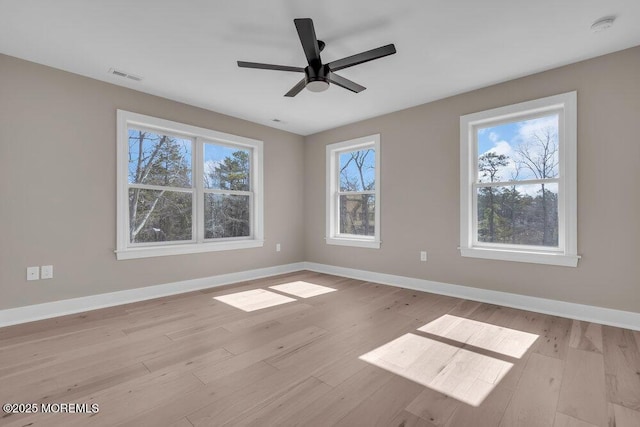 empty room featuring light wood-type flooring, baseboards, a smoke detector, and ceiling fan