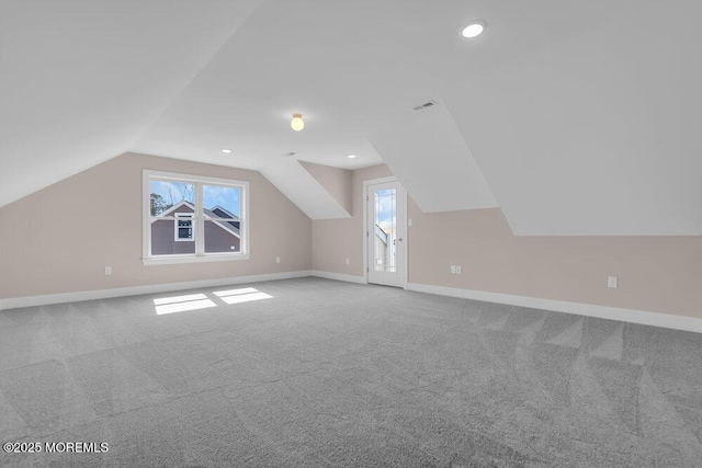 additional living space with carpet flooring, plenty of natural light, baseboards, lofted ceiling, and recessed lighting