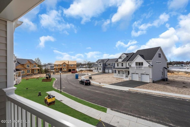 view of asphalt road with a residential view, sidewalks, and curbs