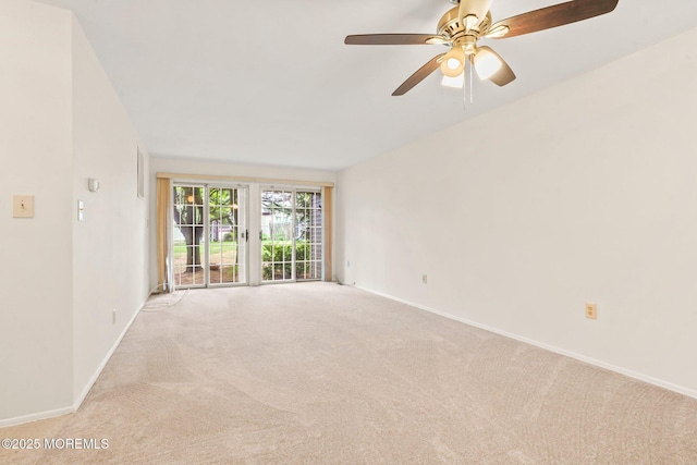 spare room with light colored carpet, baseboards, and ceiling fan