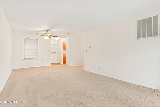 empty room featuring light carpet, ceiling fan, and baseboards