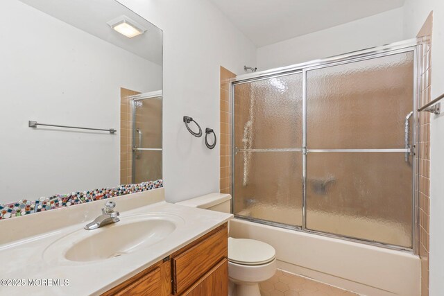 full bath with toilet, vanity, combined bath / shower with glass door, and tile patterned floors