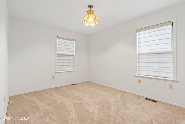 carpeted spare room featuring baseboards
