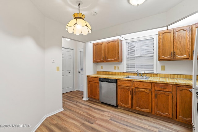 kitchen featuring stainless steel dishwasher, a sink, light wood-style flooring, and brown cabinets