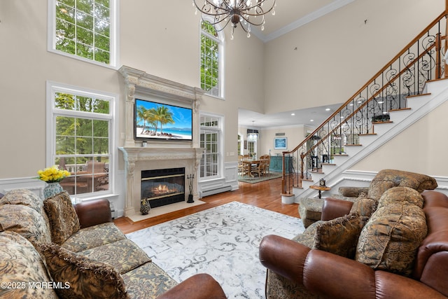 68 Hedgerow Ln, Manalapan, NJ 07726 - living room with a chandelier, a baseboard radiator, stairs, crown molding, and wood finished floors
