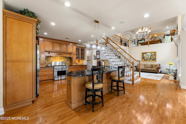 68 Hedgerow Ln, Manalapan, NJ 07726 - kitchen with appliances with stainless steel finishes, light wood-type flooring, a breakfast bar, brown cabinets, and recessed lighting