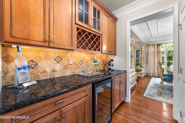 68 Hedgerow Ln, Manalapan, NJ 07726 - kitchen featuring beverage cooler, wood finished floors, brown cabinets, ornamental molding, and dark stone counters