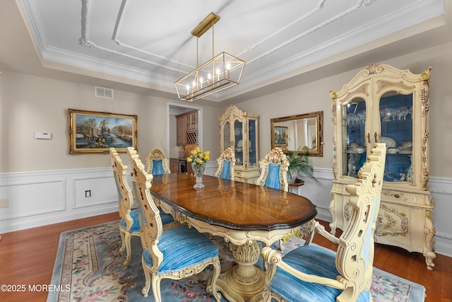 68 Hedgerow Ln, Manalapan, NJ 07726 - dining area with a raised ceiling, a chandelier, wood finished floors, crown molding, and wainscoting