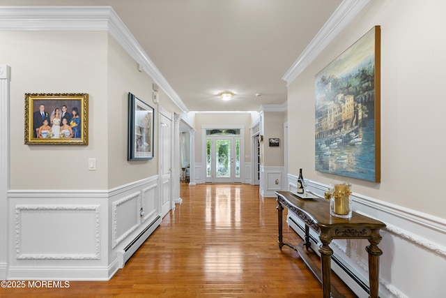 68 Hedgerow Ln, Manalapan, NJ 07726 - hallway with a baseboard heating unit, a decorative wall, crown molding, light wood-style floors, and a wainscoted wall