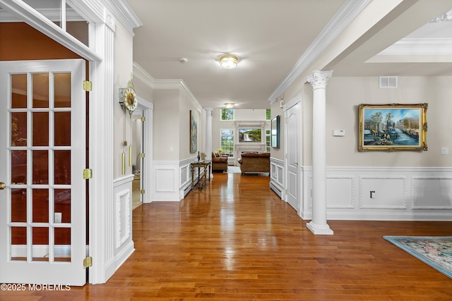 68 Hedgerow Ln, Manalapan, NJ 07726 - hall featuring decorative columns, wood finished floors, ornamental molding, a decorative wall, and a wainscoted wall