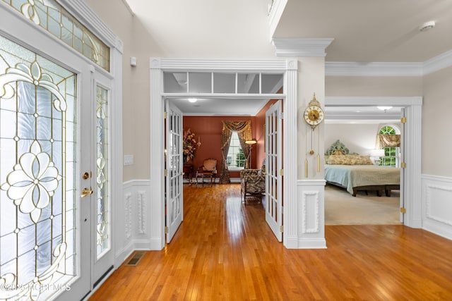 68 Hedgerow Ln, Manalapan, NJ 07726 - foyer featuring crown molding, wood finished floors, wainscoting, and a decorative wall