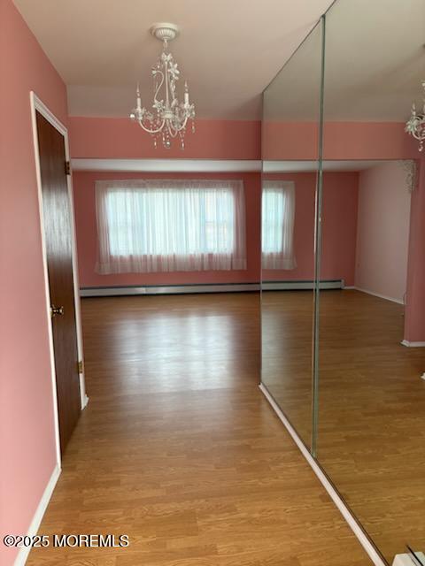 4 Flamingo Way, Toms River, NJ 08757 - corridor with a chandelier, wood finished floors, baseboards, and baseboard heating