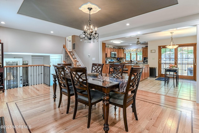 dining room with light wood-type flooring, ceiling fan, a chandelier, recessed lighting, and baseboards