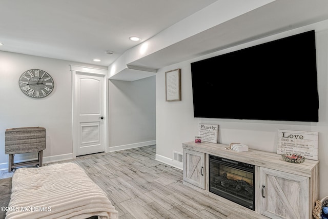living room with baseboards, recessed lighting, and light wood-type flooring