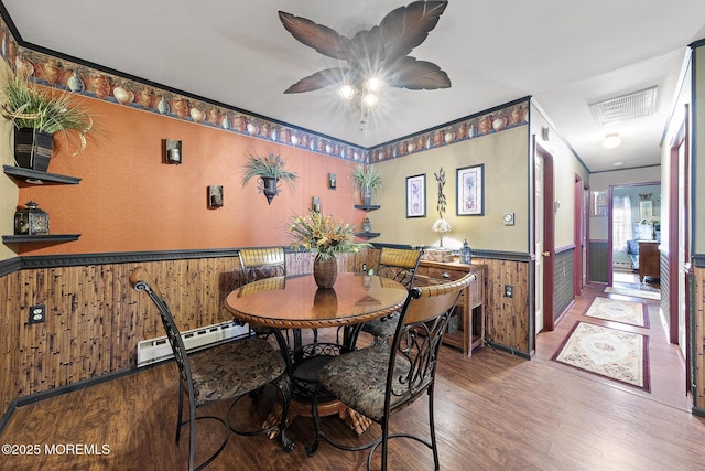 22 Fir Rd Unit 25, Manahawkin, NJ 08050 - dining room featuring baseboard heating, wainscoting, wood finished floors, ceiling fan, and wooden walls