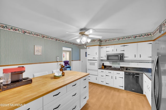 1223 Clover Rd, Brick, NJ 08724 - kitchen with appliances with stainless steel finishes, a warming drawer, ceiling fan, white cabinets, and a wainscoted wall