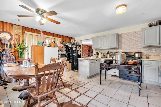 211 Long Swamp Rd, New Egypt, NJ 08533 - kitchen with gray cabinetry, ceiling fan, light countertops, wood walls, and light tile patterned flooring