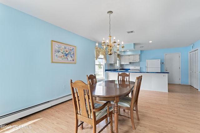 dining space featuring a baseboard heating unit, a chandelier, light wood finished floors, and recessed lighting