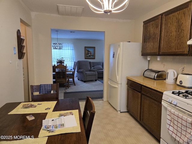 15 Roxton Pl, Toms River, NJ 08757 - kitchen featuring a chandelier, white appliances, dark brown cabinetry, light countertops, and pendant lighting