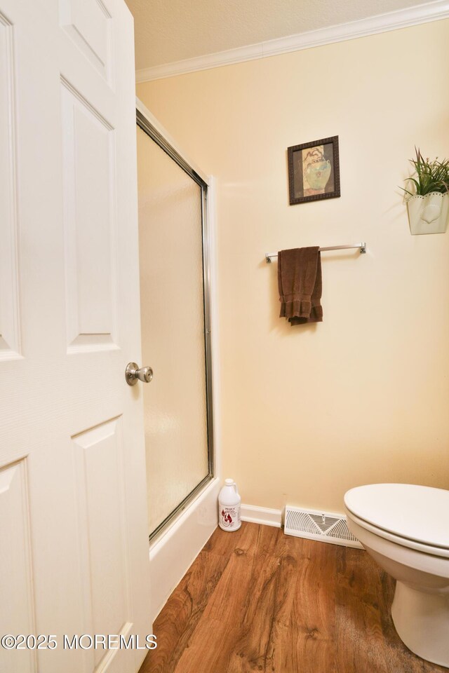 39 Goldenrod Pl, Jackson, NJ 08527 - bathroom featuring crown molding, wood finished floors, a shower with shower door, toilet, and baseboards