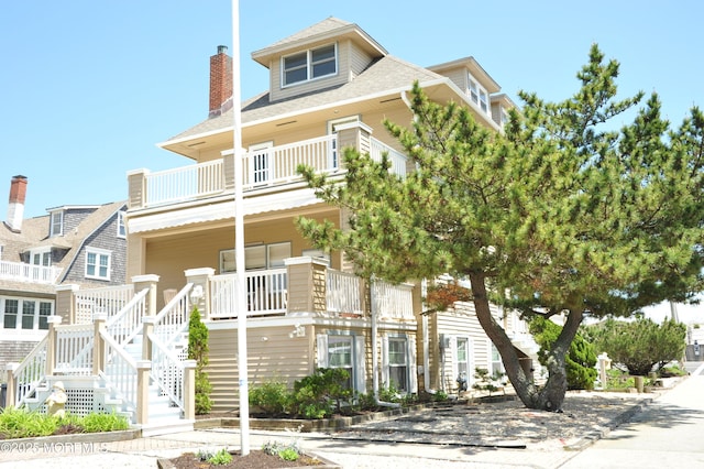 817 S Ocean Ave, Seaside Park, NJ 08752 - view of front of property with a balcony, a porch, a chimney, and a shingled roof