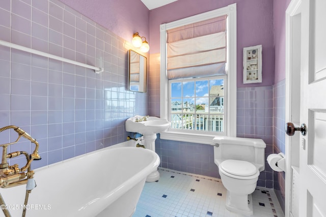 817 S Ocean Ave, Seaside Park, NJ 08752 - bathroom with tile walls, a soaking tub, tile patterned floors, toilet, and wainscoting
